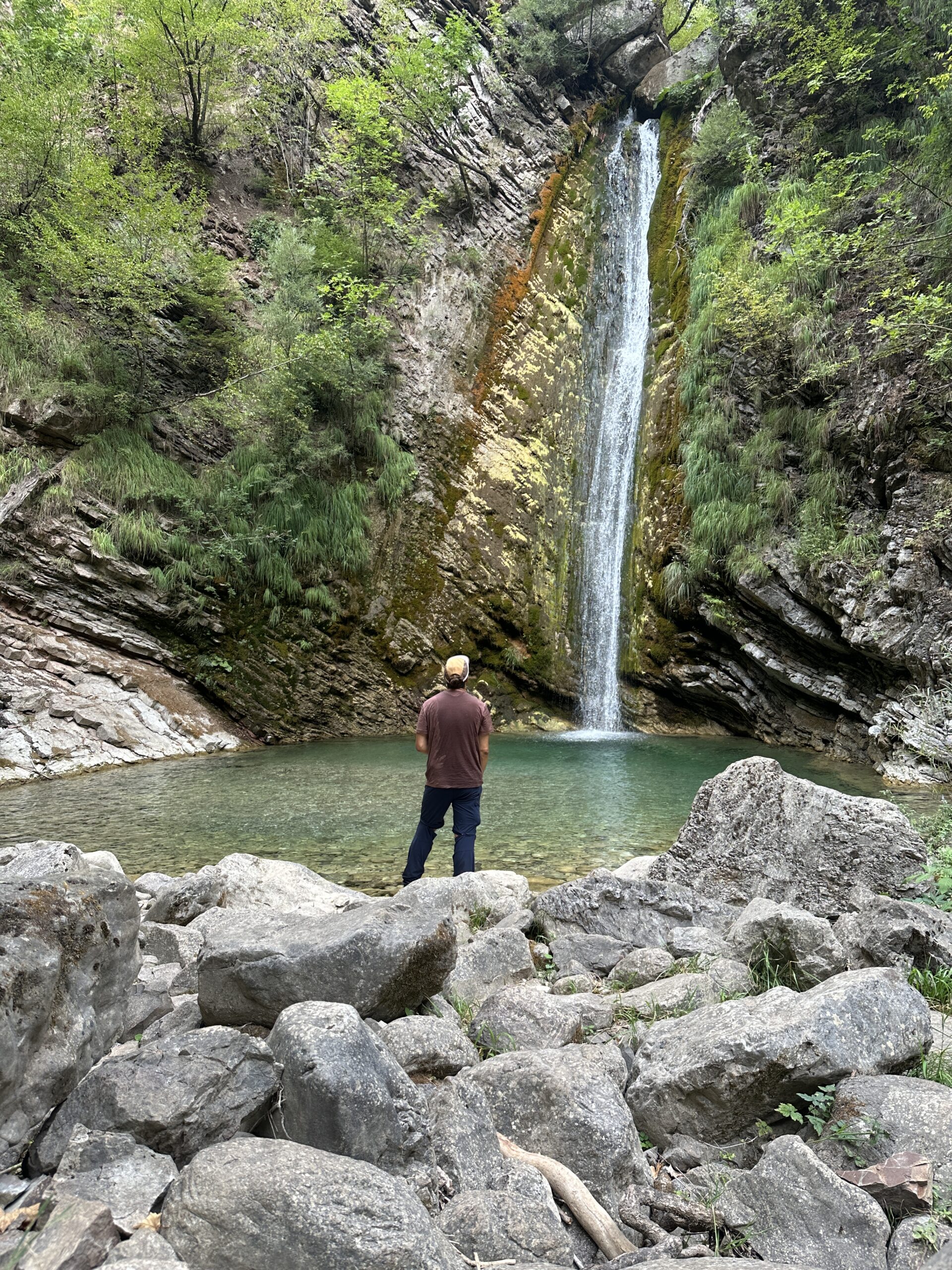 Un scout en train d’observer une chute d’eau.