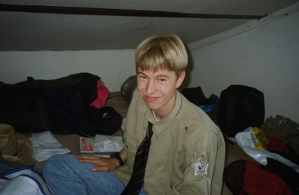 Le jeune Fäger en chemise scoute dans le dortoir