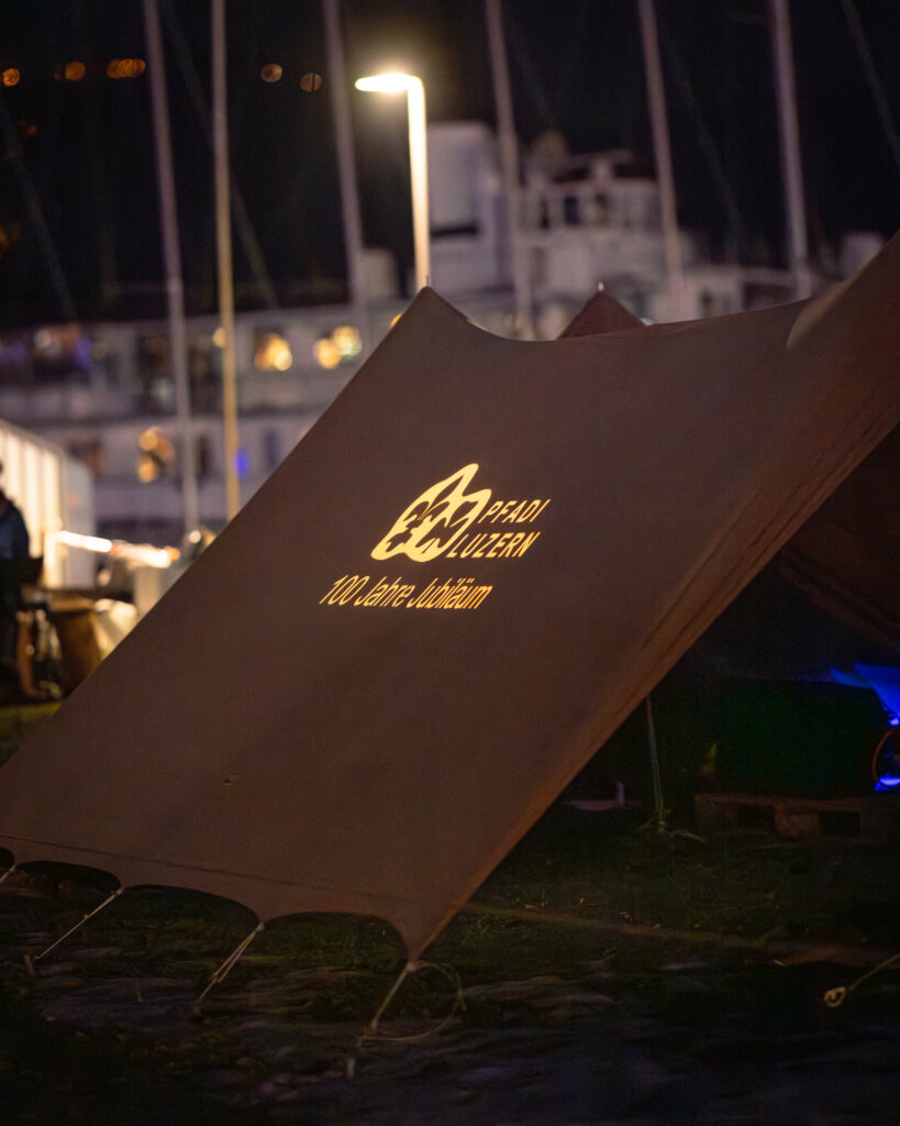Le logo du centenaire des Pfadi Luzern a été projeté sur une tente.