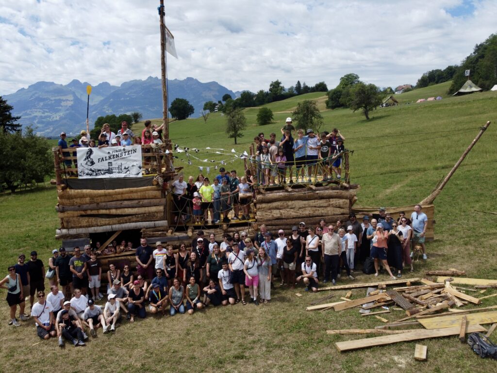 Die Pfadiabteilung Falkenstein Basel - Binningen posiert fürs Gruppenfoto vor dem selbstgebauten Piratenschiff.